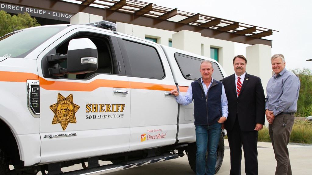 Direct Relief CEO Thomas Tighe, Santa Barbara County Sheriff Bill Brown, and SBC Search and Rescue Commander Nelson Trichler in front of the new Search vehicle. (Noah Smith/Direct Relief)