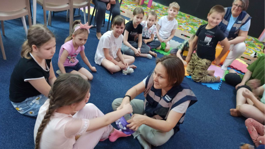 A Ukrainian emergency psychologist interacts with children in a flood-affected community. (Melinda Endrefy/Hromada Hub)